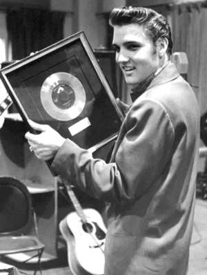 Understanding RIAA Gold Records: Elvis Presley holding his first RCA Victor in-house gold record award for "Heartbreak Hotel" in 1956.